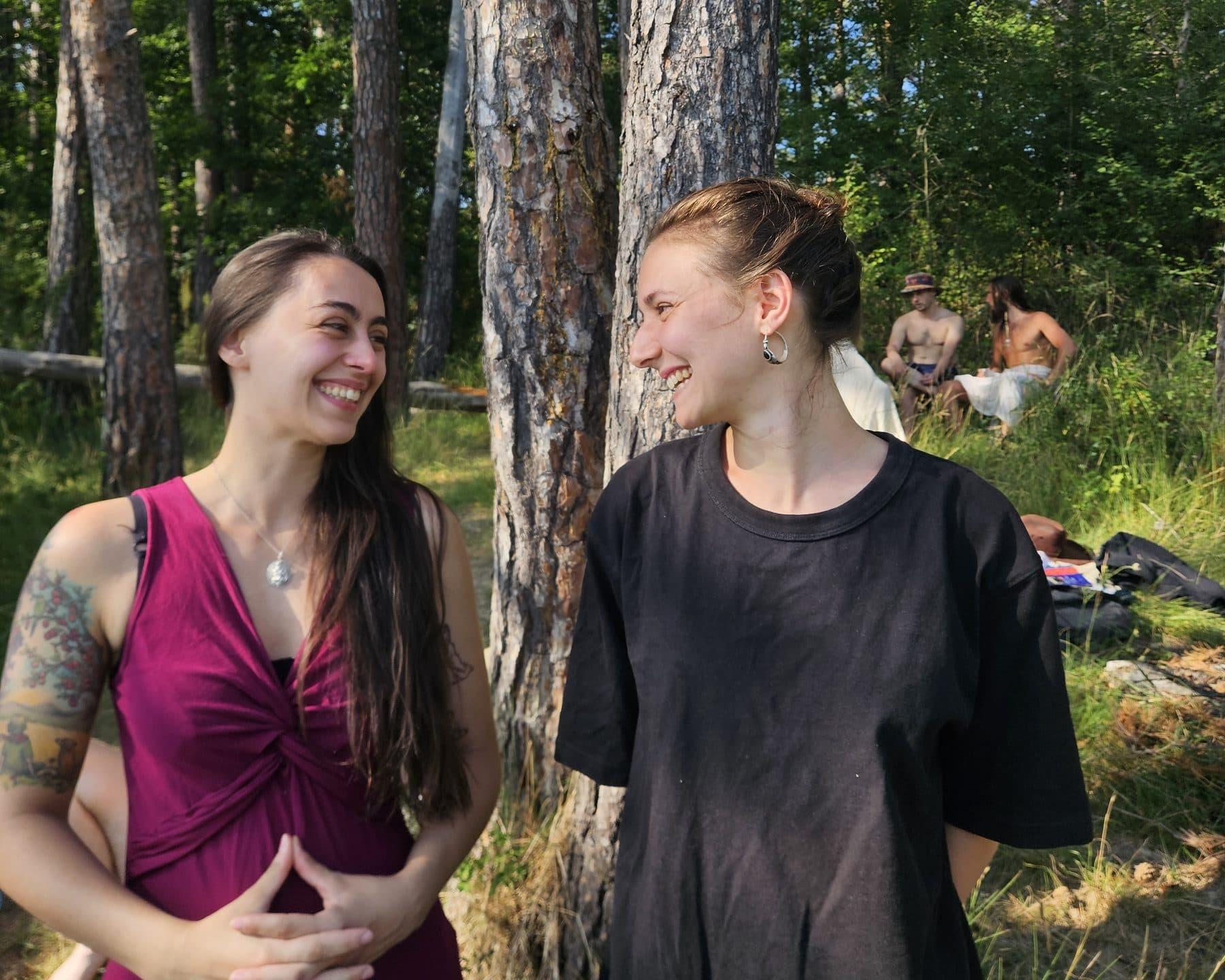 Two residents laughing together in the pine forest during the France residency