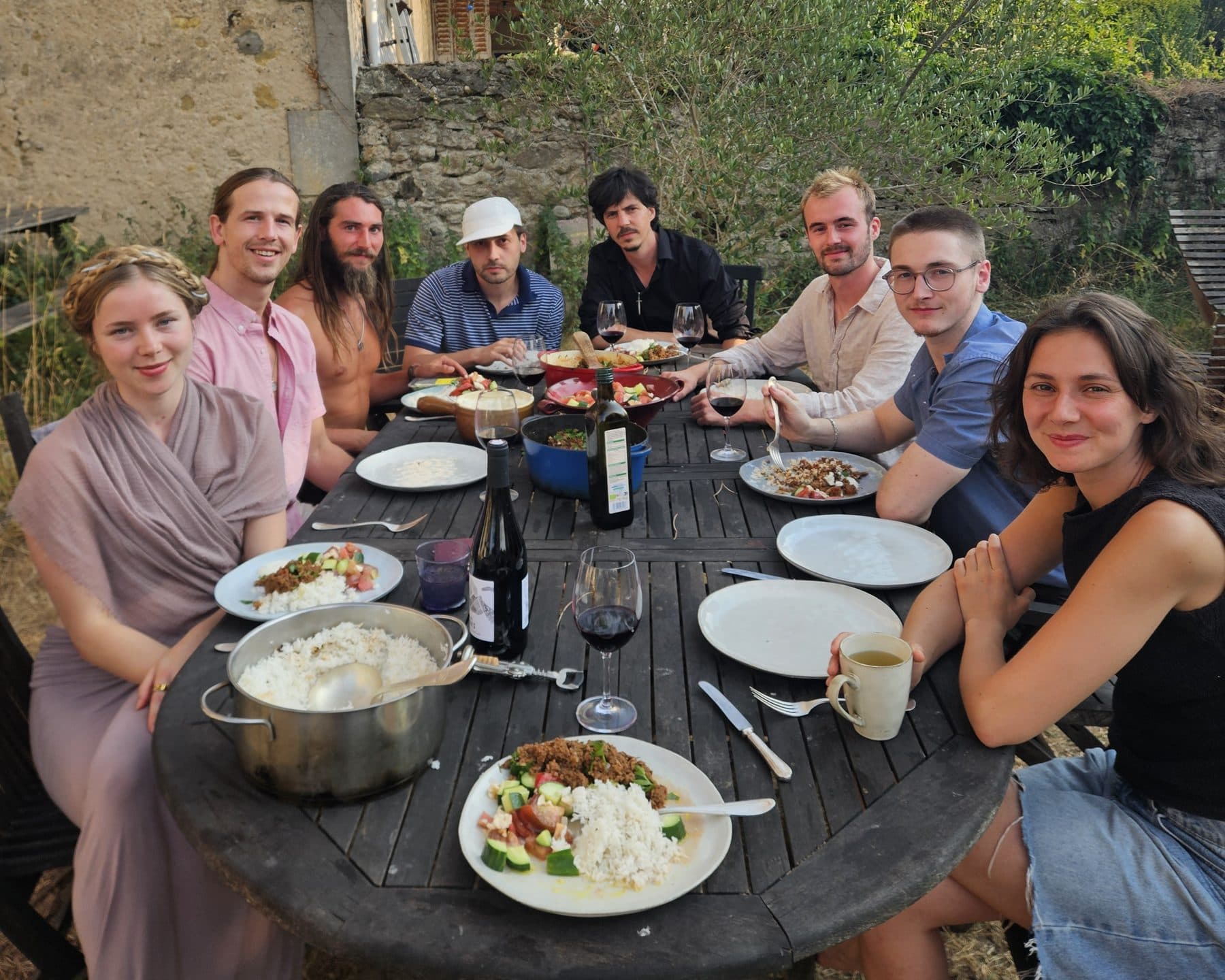 Residents sharing dinner at the long garden table during the France residency